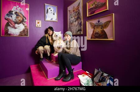 Mississauga, Kanada. 20th. November 2021. Tierhunde posieren mit ihren Besitzern an einem Tierfotostand während der Toronto Christmas Pet Show am 20. November 2021 in Mississauga, dem Großraum Toronto, Kanada, für Fotos. Von Samstag bis Sonntag findet hier die Familienschau statt, bei der Wettbewerbe für Haustiere, ein Ferienmarkt, Fotokabinen für Haustiere und vieles mehr angeboten werden. Quelle: Zou Zheng/Xinhua/Alamy Live News Stockfoto