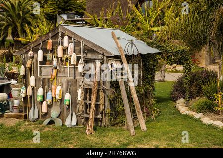 Viele alte Bojen hängen an der Seite eines Holzschuppens. Stockfoto