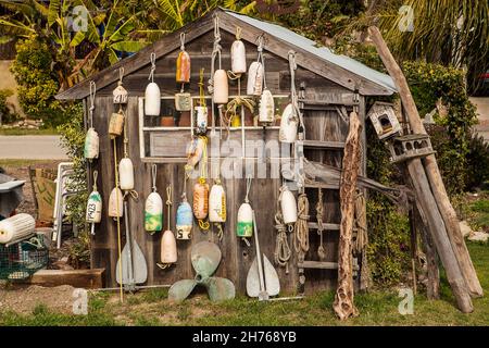 Viele alte Bojen hängen an der Seite eines Holzschuppens. Stockfoto