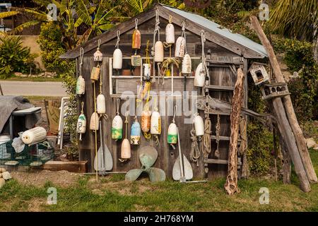 Viele alte Bojen hängen an der Seite eines Holzschuppens. Stockfoto