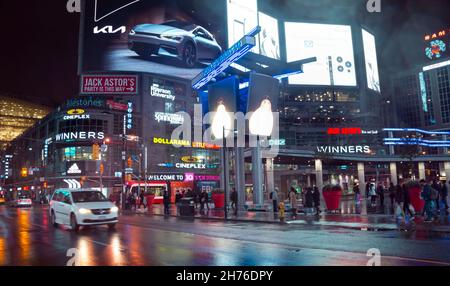 Toronto, Kanada - 10 30 2021: Regennacht-Ansicht auf Yonge-Dundas Square in der Innenstadt von Toronto mit riesigen Werbe-Video-Bildschirme, Schilder, Lichter reflektin Stockfoto