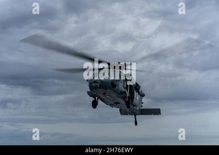 211117-N-FA490-1258 SÜDCHINESISCHES MEER (NOV 17, 2021) Ein MH-60s Hubschrauber, der den „Wildcards“ der Helicopter Sea Combat (HSC) Squadron 23 zugeordnet ist, hebt während Routineoperationen vom Flugdeck des Independence-Variant Littoral Combat Ship USS Jackson (LCS 6) ab. Jackson, Teil von Destroyer Squadron Seven, ist im US-7th-Flottenbereich im Einsatz, um die Interoperabilität mit Partnern zu verbessern und als einsatzbereite Kraft zur Unterstützung einer freien und offenen Region im Indo-Pazifik-Raum zu fungieren. (USA Navy Foto von Mass Communication Specialist 3rd Class Andrew Langholf/veröffentlicht) Stockfoto