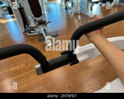 Behinderte Person mit Bicep Curl Machine. Stockfoto