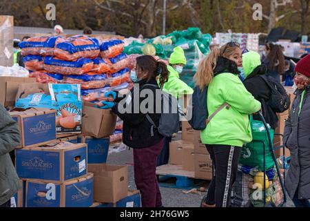 NEW YORK, NY – 20. NOVEMBER: Bei einer Imbiß-Bank erhalten die Menschen am 20. November 2021 in Queens Borough in New York City ein kostenloses Essen. Die Gouverneurin Kathy Hochul unterzeichnet ein Gesetz, in dem das Nourish New York-Programm dauerhaft im Staatsrecht verankert ist. Die Unterzeichnung dieses Gesetzes erfolgt kurz vor dem Erntedankfest und bekräftigt die Verpflichtung von New York, Menschen mit Ernährungsunsicherheit im ganzen Staat zu unterstützen. Stockfoto