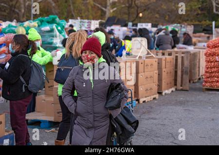 NEW YORK, NY – 20. NOVEMBER: Bei einer Imbiß-Bank erhalten die Menschen am 20. November 2021 in Queens Borough in New York City ein kostenloses Essen. Die Gouverneurin Kathy Hochul unterzeichnet ein Gesetz, in dem das Nourish New York-Programm dauerhaft im Staatsrecht verankert ist. Die Unterzeichnung dieses Gesetzes erfolgt kurz vor dem Erntedankfest und bekräftigt die Verpflichtung von New York, Menschen mit Ernährungsunsicherheit im ganzen Staat zu unterstützen. Stockfoto
