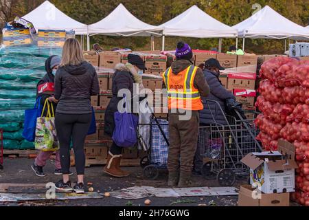 NEW YORK, NY – 20. NOVEMBER: Bei einer Imbiß-Bank erhalten die Menschen am 20. November 2021 in Queens Borough in New York City ein kostenloses Essen. Die Gouverneurin Kathy Hochul unterzeichnet ein Gesetz, in dem das Nourish New York-Programm dauerhaft im Staatsrecht verankert ist. Die Unterzeichnung dieses Gesetzes erfolgt kurz vor dem Erntedankfest und bekräftigt die Verpflichtung von New York, Menschen mit Ernährungsunsicherheit im ganzen Staat zu unterstützen. Stockfoto