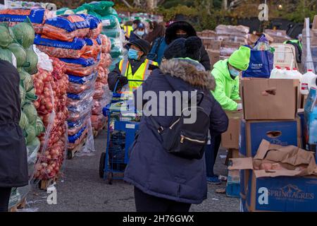 NEW YORK, NY – 20. NOVEMBER: Bei einer Imbiß-Bank erhalten die Menschen am 20. November 2021 in Queens Borough in New York City ein kostenloses Essen. Die Gouverneurin Kathy Hochul unterzeichnet ein Gesetz, in dem das Nourish New York-Programm dauerhaft im Staatsrecht verankert ist. Die Unterzeichnung dieses Gesetzes erfolgt kurz vor dem Erntedankfest und bekräftigt die Verpflichtung von New York, Menschen mit Ernährungsunsicherheit im ganzen Staat zu unterstützen. Stockfoto