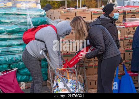 NEW YORK, NY – 20. NOVEMBER: Bei einer Imbiß-Bank erhalten die Menschen am 20. November 2021 in Queens Borough in New York City ein kostenloses Essen. Die Gouverneurin Kathy Hochul unterzeichnet ein Gesetz, in dem das Nourish New York-Programm dauerhaft im Staatsrecht verankert ist. Die Unterzeichnung dieses Gesetzes erfolgt kurz vor dem Erntedankfest und bekräftigt die Verpflichtung von New York, Menschen mit Ernährungsunsicherheit im ganzen Staat zu unterstützen. Stockfoto