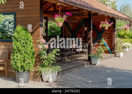 Eine offene Holzverande, auf der Sie an einem sonnigen Sommertag im Park Garden of Dreams Ihr eigenes Essen essen können. Stockfoto