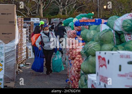 NEW YORK, NY – 20. NOVEMBER: Bei einer Imbiß-Bank erhalten die Menschen am 20. November 2021 in Queens Borough in New York City ein kostenloses Essen. Die Gouverneurin Kathy Hochul unterzeichnet ein Gesetz, in dem das Nourish New York-Programm dauerhaft im Staatsrecht verankert ist. Die Unterzeichnung dieses Gesetzes erfolgt kurz vor dem Erntedankfest und bekräftigt die Verpflichtung von New York, Menschen mit Ernährungsunsicherheit im ganzen Staat zu unterstützen. Stockfoto