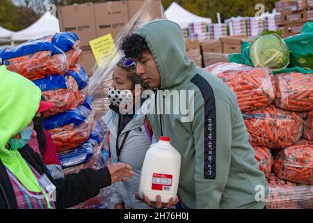 NEW YORK, NY – 20. NOVEMBER: Bei einer Imbiß-Bank erhalten die Menschen am 20. November 2021 in Queens Borough in New York City ein kostenloses Essen. Die Gouverneurin Kathy Hochul unterzeichnet ein Gesetz, in dem das Nourish New York-Programm dauerhaft im Staatsrecht verankert ist. Die Unterzeichnung dieses Gesetzes erfolgt kurz vor dem Erntedankfest und bekräftigt die Verpflichtung von New York, Menschen mit Ernährungsunsicherheit im ganzen Staat zu unterstützen. Stockfoto