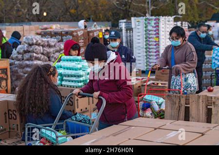 NEW YORK, NY – 20. NOVEMBER: Bei einer Imbiß-Bank erhalten die Menschen am 20. November 2021 in Queens Borough in New York City ein kostenloses Essen. Die Gouverneurin Kathy Hochul unterzeichnet ein Gesetz, in dem das Nourish New York-Programm dauerhaft im Staatsrecht verankert ist. Die Unterzeichnung dieses Gesetzes erfolgt kurz vor dem Erntedankfest und bekräftigt die Verpflichtung von New York, Menschen mit Ernährungsunsicherheit im ganzen Staat zu unterstützen. Stockfoto