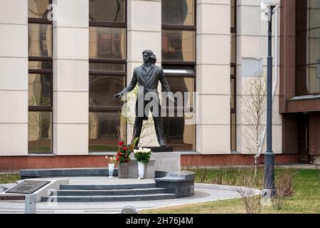 Denkmal des Opernsängers Dmitri Hvorostovsky vor dem Hintergrund des im Frühjahr nach ihm benannten Sibirischen Staatlichen Kunstinstituts. Stockfoto