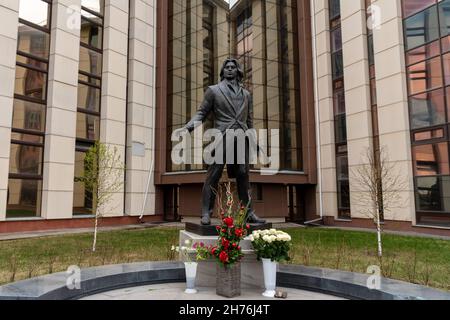 Denkmal für den Opernsänger Dmitri Hvorostovsky vor dem Hintergrund des D. Hvorostovsky Sibirischen Staatlichen Instituts der Künste im Frühjahr. Stockfoto