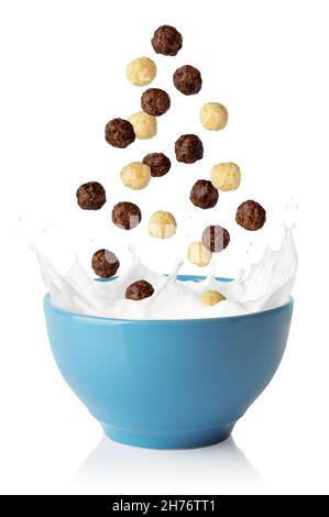 Vanille- und Schokoladenmaiskugeln fallen in eine blaue Schüssel Stockfoto