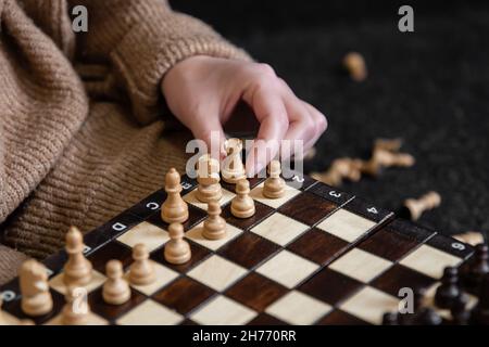 Frau, die Schachfiguren auf ein Schachbrett legt. Stockfoto