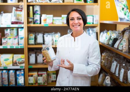 Verkäuferin, die Getreideprodukte hält Stockfoto