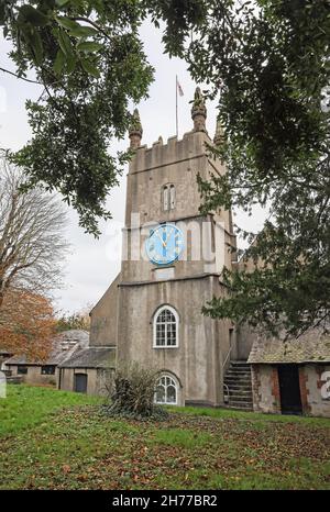 Westliche Erhebung der Stoke Damerel Church in Plymouth. Die Flagge von St. George, die über seinem Turm aus dem 15th. Jahrhundert schweben. Die große Uhr, die dominiert Stockfoto