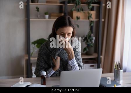 Ungesund gestresste junge Geschäftsfrau mit Papiertuch. Stockfoto