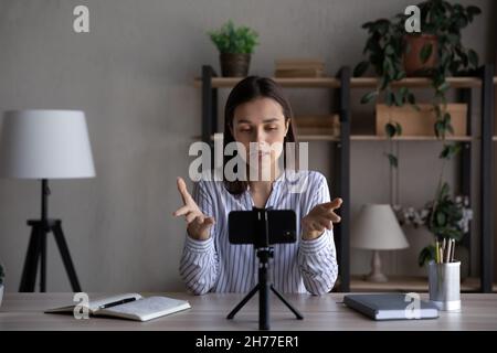 Konzentrierte junge, qualifizierte weibliche Business Trainerin, die Videos auf dem Handy aufzeichnete. Stockfoto