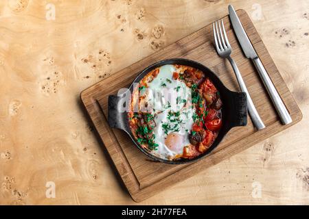Shakshuka in der Pfanne. Eier in würziger Tomatenpfeffer-Sauce pochiert. Stockfoto