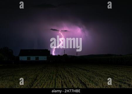 Blitzschlag schlägt hinter einem Haus in der Landschaft von Siebenbürgen, Rumänien Stockfoto