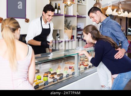 Lächelnder Pastryman, der köstliche Teestube anbietet Stockfoto