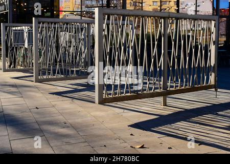 Moderne pulverbeschichtete Aluminium niedrigen Zaun und Drehtor auf Stahl.post Pivot. Straßenlandschaft Hintergrund. Stein gepflastert Bürgersteig. Abnehmende Perspektive. Stockfoto