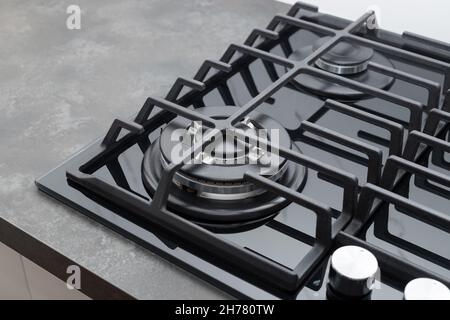 Schwarzer Gasherd auf dunkler Arbeitsplatte zu Hause Stockfoto