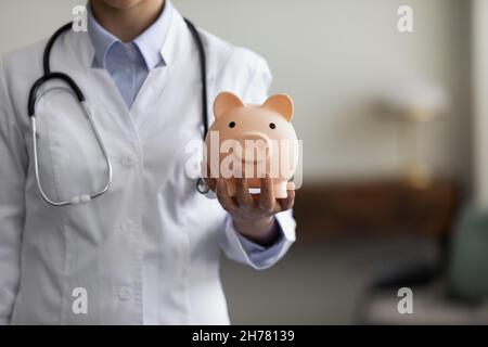 Crope close up Ärztin hält rosa Sparschwein Stockfoto