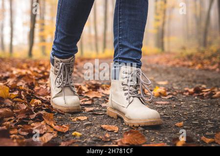 Wandern mit Wanderschuhen auf der Straße im Herbstwald Stockfoto