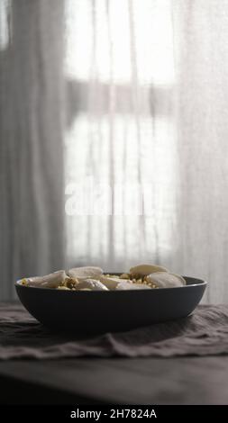 Pesto fusilli mit Mozzarella in blauer Schale mit natürlichem Licht, vertikaler Schuss Stockfoto