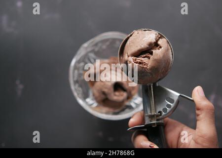 Pflücken Sie Eis mit einem Löffel aus einer Schüssel Stockfoto