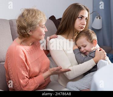 Zwei Erwachsene Frauen haben Meinungsverschiedenheiten mit dem erwachenden Kind Stockfoto