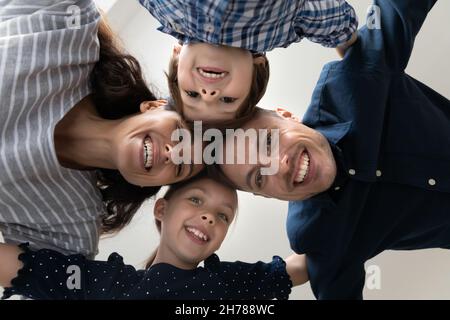 Die Ansicht von unten zeigt Familien mit Kindern, die lächeln und die Kamera betrachten Stockfoto