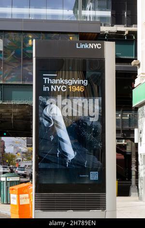 Eine LINKNYC-Maschine am Broadway in Astoria mit einem Rückblende-Foto der Macy's Thanksgiving Day Parade 1946. In Queens, New York City. Stockfoto