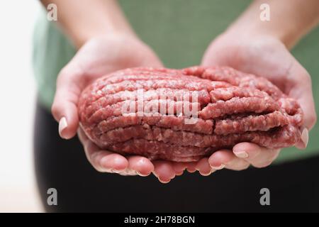 Weibliche Hände halten frisches Hackfleisch, Nahaufnahme Stockfoto