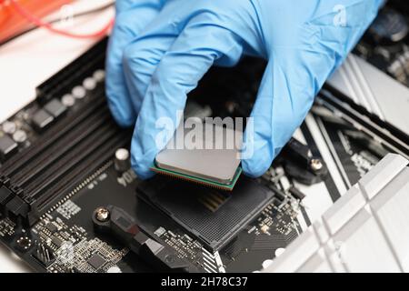 Eine Hand in Handschuhen hält einen Mikrokreis über dem Gerät Stockfoto