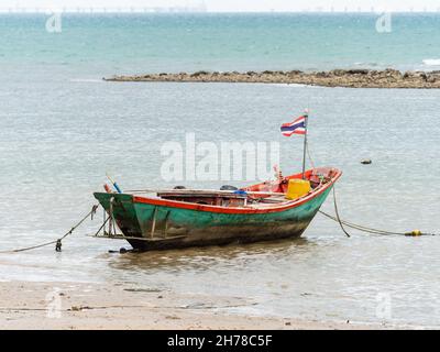 Kleines Fischerboot, das am Pala Beach in Ban Chang in der Provinz Rayong in Thailand festgemacht ist. Die Ölpipeline im Industriegebiet Map Ta Phut ist zu sehen Stockfoto