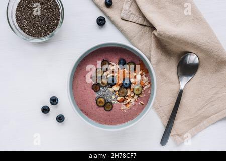 Gesunde, geglättet Schüssel mit Chiasamen, Heidelbeeren, Nüssen und Erdnussbutter. Veganes Frühstück, Blick von oben, flach liegend. Stockfoto