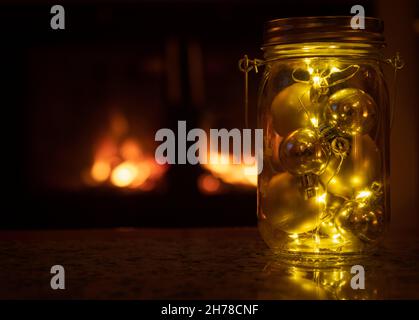 Weihnachtliches Herzstück vor dem beleuchteten Kamin Stockfoto