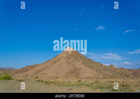 Mount mit einer idealen konischen Vulkanform wird von der aufgehenden Sonne im iran mit blauem Himmel beleuchtet Stockfoto