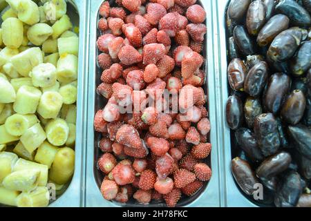 Präsentation von gefrorenen Früchten in einem Laden für gefrorene Joghurt (von links nach rechts), Bananen, Erdbeeren und Datteln Stockfoto