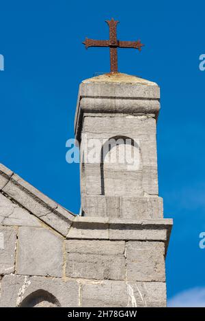 Rostiges religiöses Kreuz über der Kirche San Lorenzo (St. Lawrence) 1098-1130, in Portovenere (UNESCO-Weltkulturerbe), La Spezia, Ligurien, Italien Stockfoto