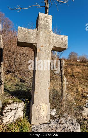 Steinkreuz (christliches Symbol) mit Inri-Inschrift in der Landschaft der Lessinia-Hochebene, der italienischen Alpen, Verona, Italien, Europa Stockfoto