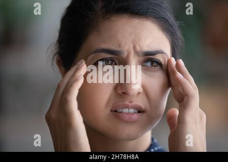 Unglücklich gestresst frustriert junge indische Frau massieren Tempel. Stockfoto