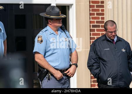 Ein Polizeibeamter des Staates Georgia steht auf den Stufen des Glynn County Courthouse als 500 schwarze Pastoren und Unterstützer sich versammeln, um für Ahmaud Arbery Gerechtigkeit zu fordern 18. November 2021 in Brunswick, Georgia. Der Prozess gegen die Angeklagten Greg McMichael, Travis McMichael und einen Nachbarn, William 'Roddie' Bryan, wurde im Gerichtsgebäude fortgesetzt. Stockfoto