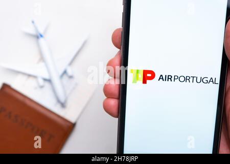 TIPPEN SIE AUF die mobile App Air Portugal Airlines. Eine praktische mobile Anwendung zum Ticketkauf per Smartphone mit Flugzeug, Reisepass und Bordkarte im Hintergrund. November 2021, San Francisco, USA Stockfoto