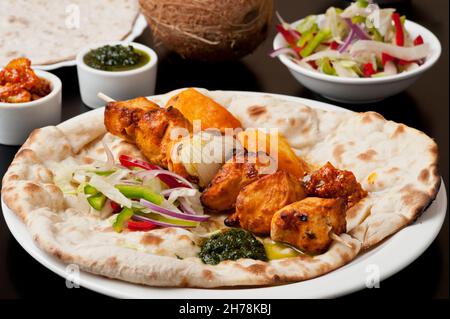 Indische ethnische Küche Tandoori Huhn auf Naan Brot Stockfoto