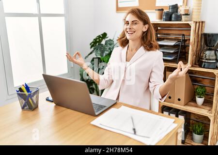 ¡Junge kaukasische Geschäftsfrau meditiert Yoga-Übungen im Büro. Stockfoto